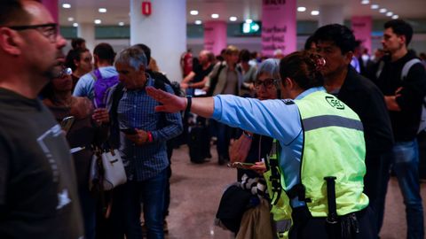 Un agente de seguridad da instrucciones en el aeropuerto de Barcelona-El Prat