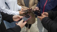 Un grupo de adolescentes con sus mviles delante del instituto Alfredo Braas de Carballo