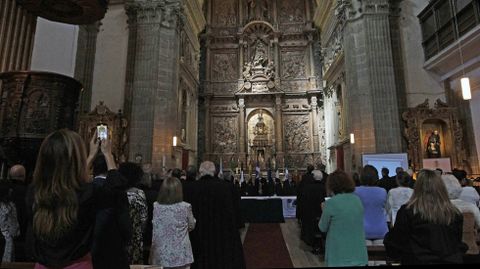 Una de las asistentes a la ceremonia hace fotos del altar principal de la iglesia de los Escolapios