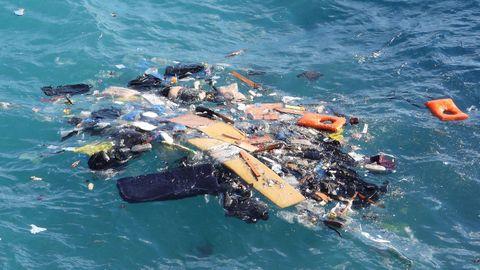 El cuerpo de un migrante flota entre los restos del velero que es estrell contra las rocas en Ctera.