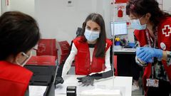 La reina Letizia (c) visita, este lunes, una de las sedes de Cruz Roja en Madrid, para conocer de primera mano la labor que desarrollan esta entidad y sus voluntarios durante la emergencia sanitaria, entre ellas, el apoyo a las personas mayores.