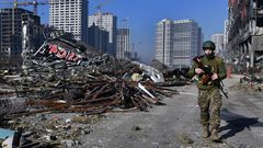 Un soldado ucraniano pasa cerca de los escombros de un importante centro comercial en Kiev que fue bombardeado el lunes.