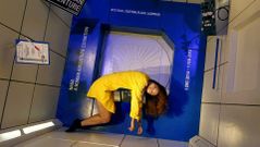 Una joven en un m�dulo de gravedad en una exposicion sobre la NASA en Tailandia.