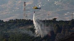 Un helic�ptero trabaja en las tareas de extinci�n del incendio declarado en Majadilla del Muerto, en la localidad malague�a de Mijas