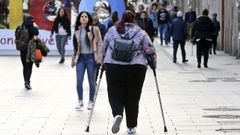 Una joven pasea con muletas por una c�ntrica calle de Vigo