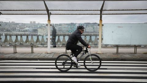 Un hombre circula en bicicleta en A Corua.