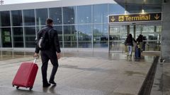 Un pasajero entrando con su maleta en el aeropuerto de Alvedro.