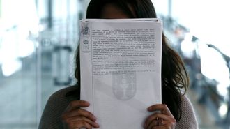 Imagen de archivo de una vctima de violencia de gnero mostrando la orden de alejamiento con su presunto agresor.