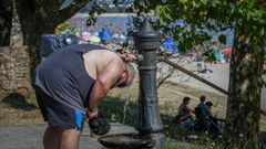 Un home utiliza nunha fonte para refrescarse en Boiro nunha das vagas de calor do ano pasado.