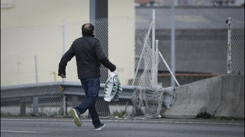Xente cruzando a mediana da estrada nunha zona comercial