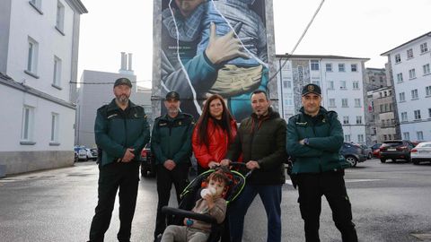 Los tres agentes, junto a Noelia, Jos� Manuel y el peque�o Bruno, posan frente al grafiti de Diego As en la Comandancia de Lugo, que retrata a un agente abrazando a un ni�o