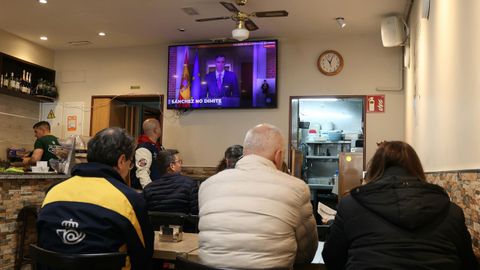 Ciudadanos siguiendo el discurso en un bar de Santiago