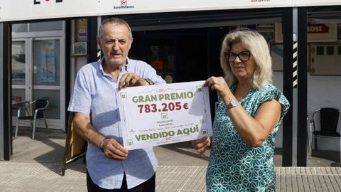 Los propietarios de la cafetera Dayshe, Sergio Gonzlez y Victoria Vispo, posan con el cartel del primer premio de la Bonoloto que se sell en su establecimiento.