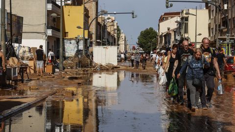 Un grupo de personas transportando bolsas a zonas en las que se han quedado sin comida ni agua 