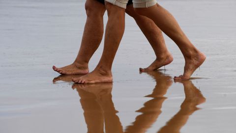 Varias personas pasean por la playa 