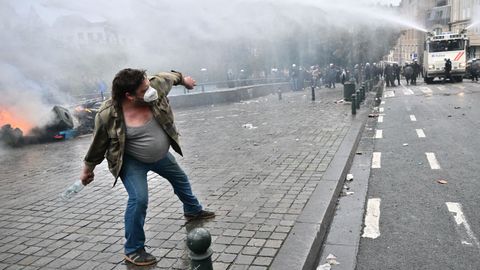 Un manifestante a punto de tirar una botella a la polic�a en Bruselas