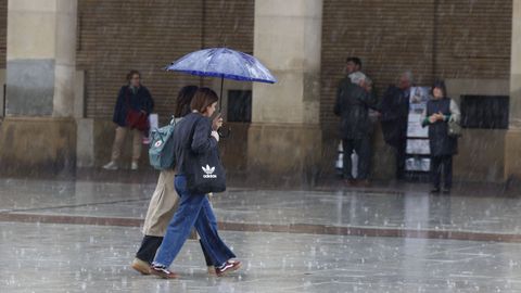 Dos ciudadanas pasean bajo la lluvia en Zaragoza el pasado mes de noviembre.
