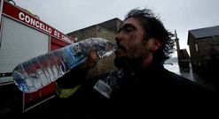 Un miembro del equipo de extinci�n de la Barca bebe agua tras salir del santuario.