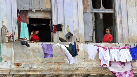Dos mujeres asomadas a los balcones de su casa, en La Habana