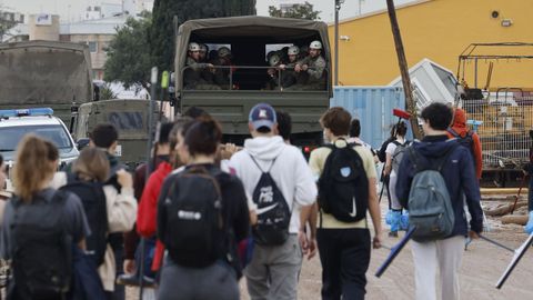 Un grupo de personas junto con un camión del Ejército caminan en dirección a Paiporta