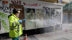 Un trabajador limpia una fachada de pintadas