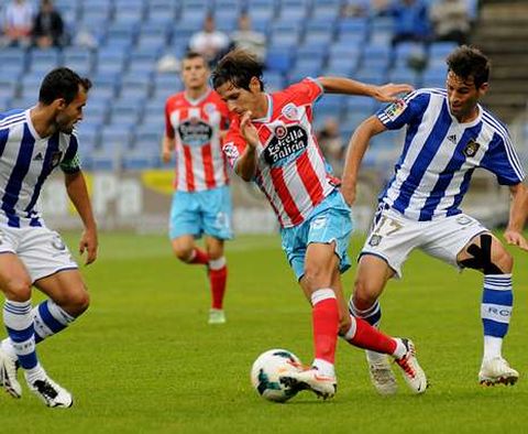 Pablo S�nchez, con el bal�n entre dos jugadores del Recreativo el pasado s�bado.