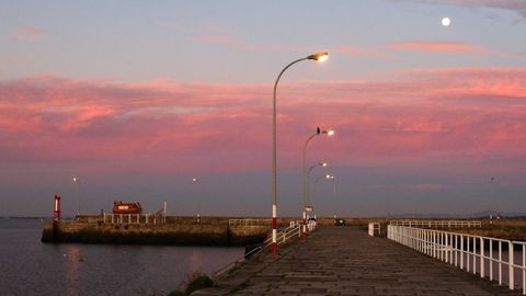 Amanecer en Cambados, con la Luna entre las nubes rosas