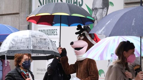  Varias personas se protegen de la lluvia con paraguas en el centro de Oviedo