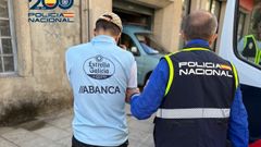 Uno de los arrestados, custodiado por un agente de Polica Nacional