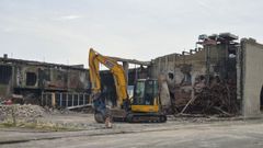 Una pala lleva a cabo los trabajos para derribar la nave da�ada el pasado abril por un incendio.