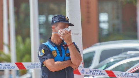 Un polica se protege con una mascarilla mientras custodia el Hotel H10 Costa Adeje Palace, donde permanecen ms de mil turistas aislados y custodiados por Polica Nacional