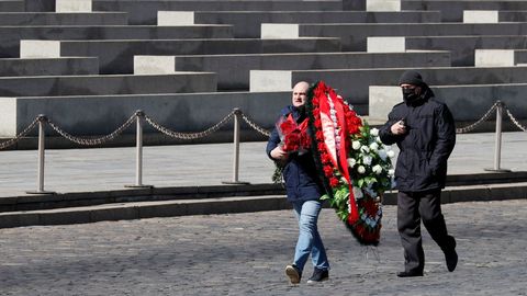 Partidarios del Partido Comunista llevan una corona de flores al mausoleo de Lenin en su 150 aniversario