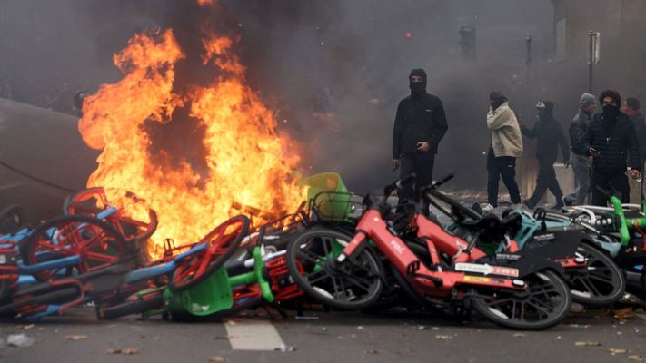 J&oacute;venes encapuchados tras una barricada formada con bicicletas p&uacute;blicas incendiadas, cerca de la plaza de la Rep&uacute;blica en Par&iacute;s.