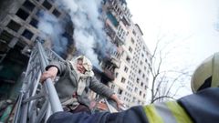 Rescatistas trabajan para sacar a una mujer de un edificio residencial que fue impactado,  en Kiev, Ucrania.
