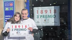 El lotero Jos� Manuel G�mez y Paula, su hijo, delante del establecimiento, con el cartel que refleja el premio.