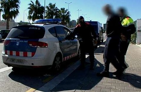 Los Mossos d?Esquadra con uno de los detenidos.