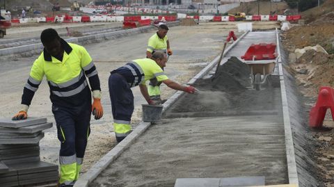 Operarios componiendo una de las aceras en O Bertn el pasado viernes.