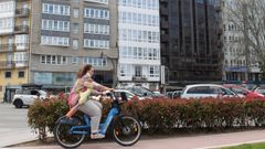 Una ciclista pasa delante del edificio que acoger� la futura residencia de San Rosendo (en el centro, con galer�as), descubierto tras su reforma integral