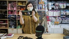 Montse G�mez, sujetando una mascarilla para sordos en su mercer�a carballi�esa, La Moderna