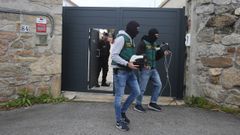 Agentes llevando m�quinas para contar billetes, durante uno de los registros.