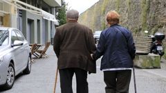 Un matrimonio de personas mayores caminando de la mano.