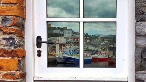 Reflejo de Luarca en los cuarterones de un cristal, imagen seleccionada por el certamen de fotograf�a en Instagram Mi Rinc�n Favorito