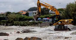 La excavadora de la empresa Tragsa estuvo trabajando ayer en la playa extendiendo los cantos rodados acumulados. 