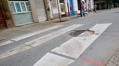 Desperfectos en un paso de peatones y pintada rosa que marca los puntos donde se reparará la calle de la Iglesia.