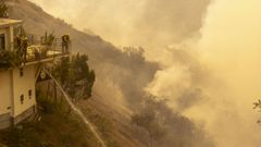 Un grupo de bomberos intentan sofocar un fuego en un barrio de Los ngeles