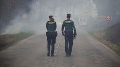 Dos agentes de la Guardia Civil regulan el trfico en el incendio de los concejos de Valdes y Tineo