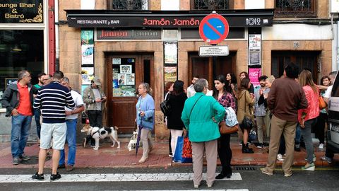 Un grupo de clientes se concentra delante del �Jam�n, Jam�n�, en Oviedo, para protestar por su clausura temporal