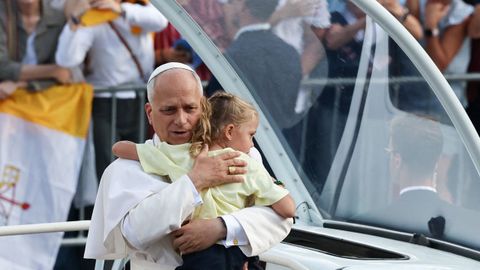 El papa abraza a una ni�a durante su recorrido en papam�vil por el estadio.