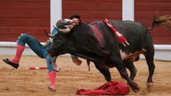 �lvaro Lorenzo sufre un revolc�n durante la faena a su primer toro durante el festejo de la feria taurina de Bego�a,