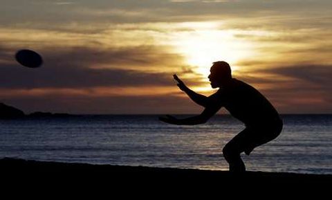 Un hombre juega con un disco en la playa de Riazor. 